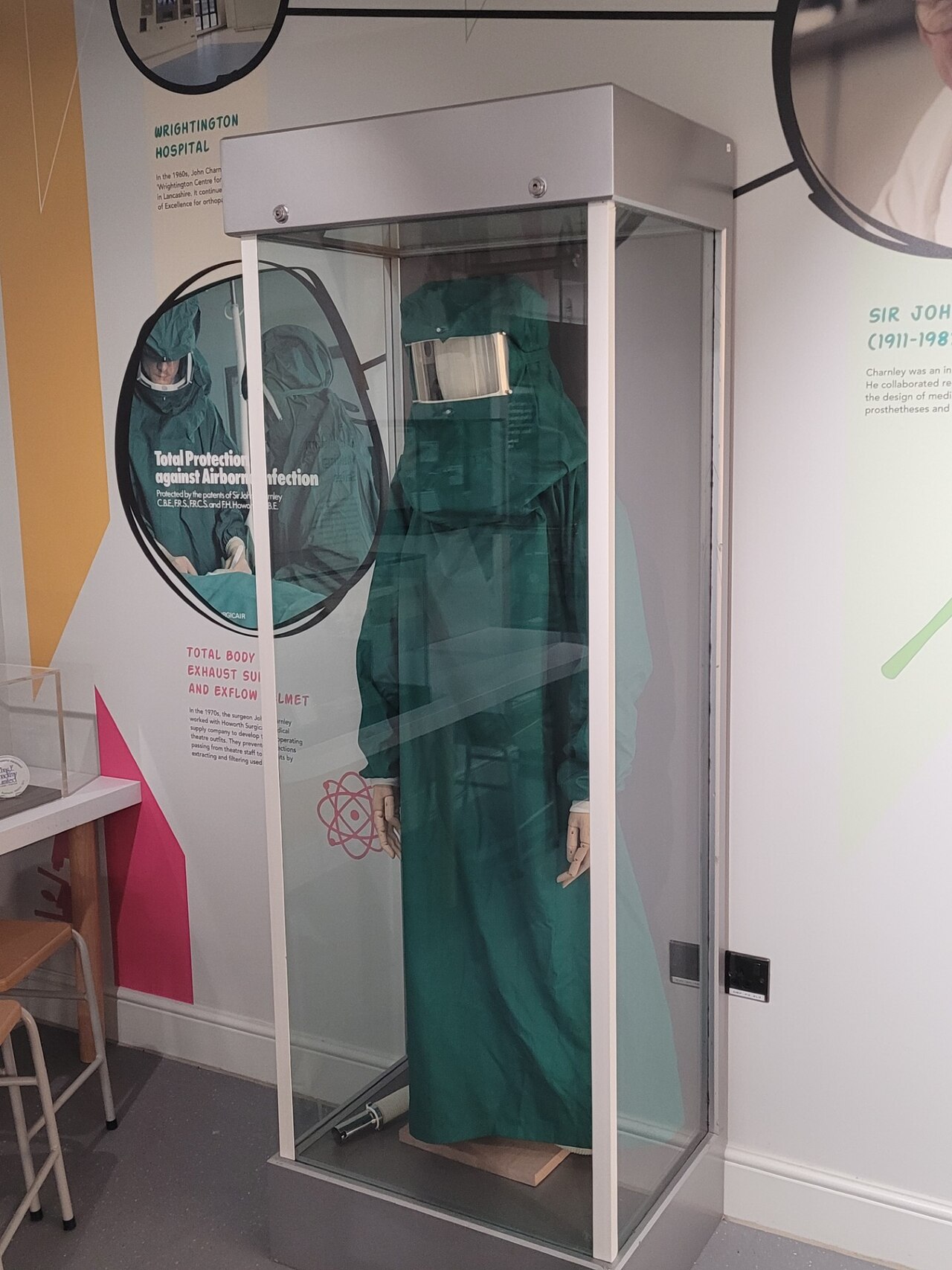 A ventilated surgical exhaust suit designed by Sir John Charnley, on display in a museum case